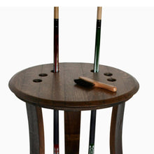 Wine Barrel Pool Cue Rack made from reclaimed wine barrel stave. Holds 6 pool stick and 1 rack of pool balls. This pool cue rack is stained in pine and has an upper shelf and lower shelf. The lower shelf has metal accents around the outside .